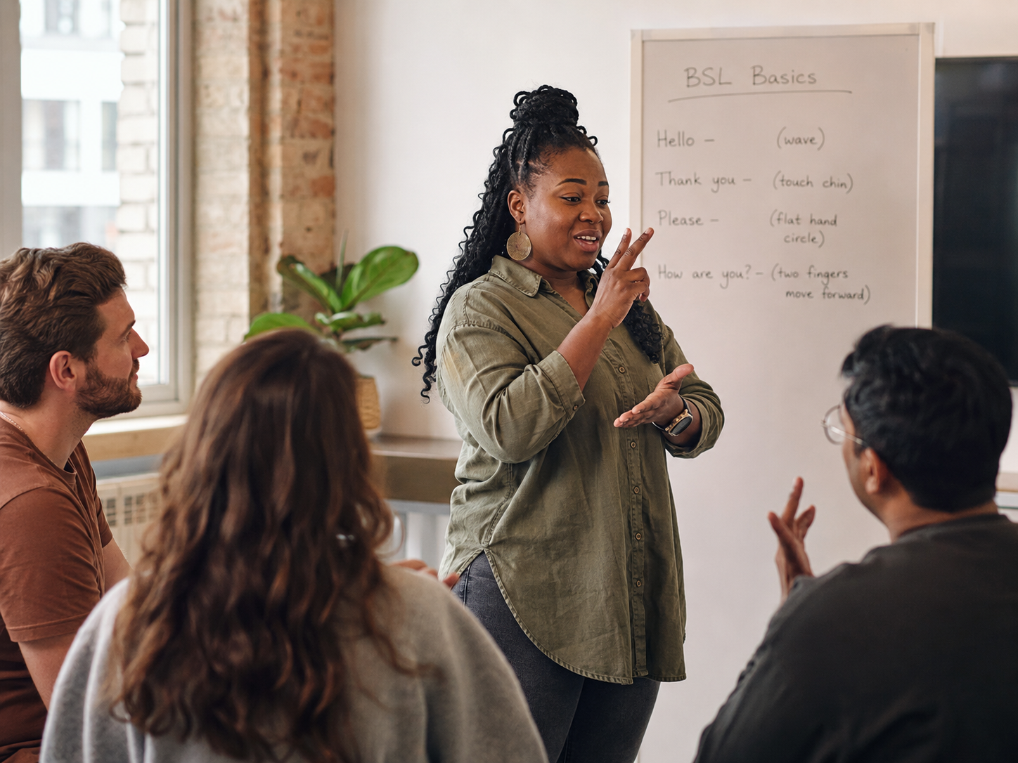 A Deaf Spaces teacher signing to learners in a BSL class